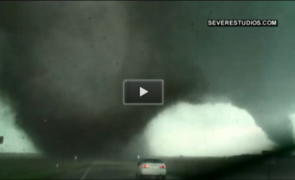Midwest ravaged by destructive tornadoes, a car in the foreground, tornadoes in the back.